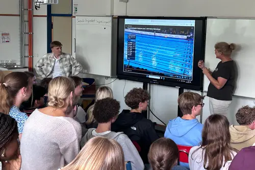 Johannes Liebmann spricht gemeinsam mit Frau Jacobs vor den aufmerksam zuhörenden Schüler*innen